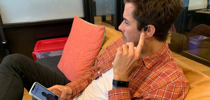 guy rests on couch wearing Melody Buds